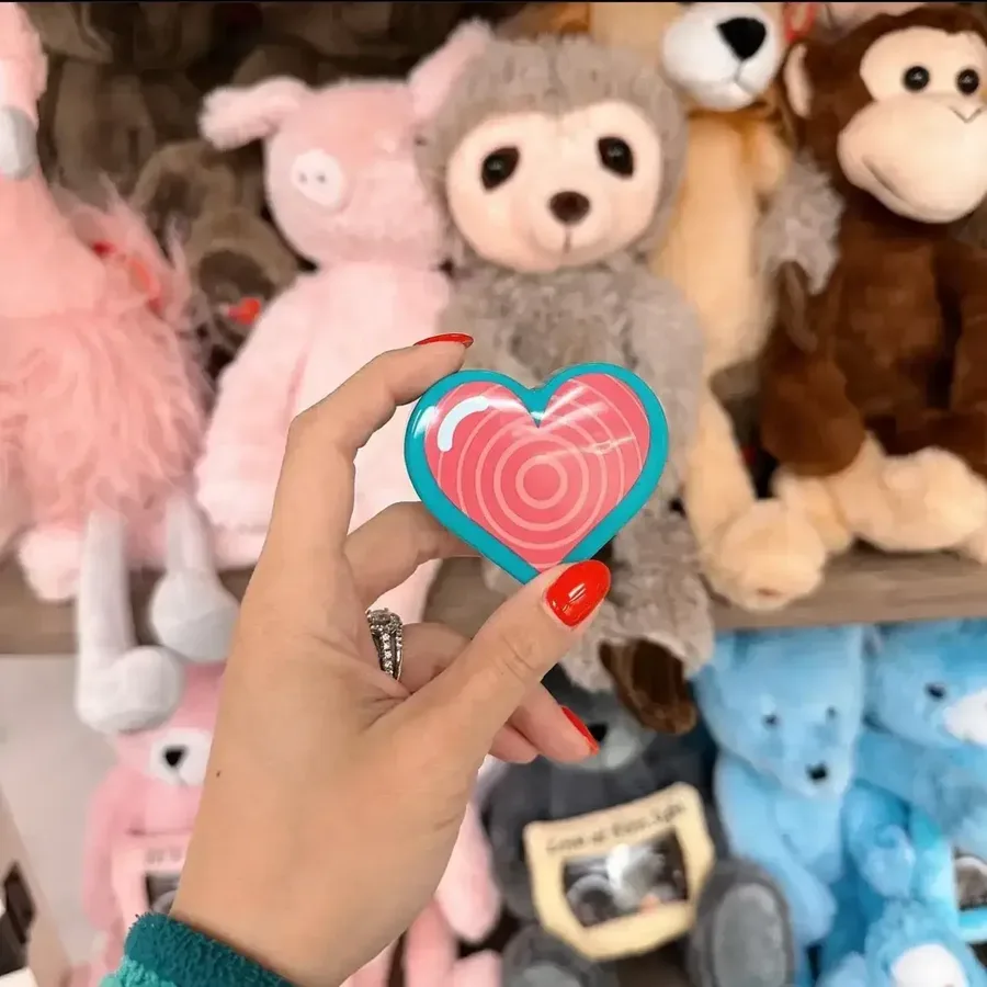 Heartbeat keepsake heart held in front of plush animals